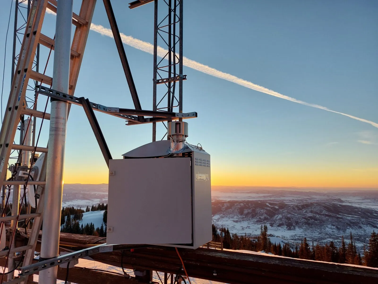 Air quality monitoring enclosure mounted on a mast at sunrise